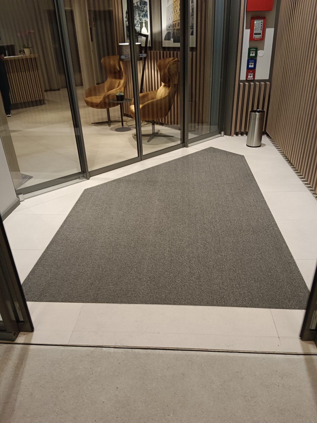Lobby-Eingang mit hellem Fliesenboden und eingelassener Schmutzfangmatte